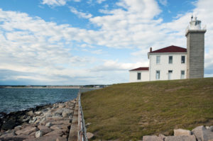 52779663 - watch hill lighthouse guides mariners along its rocky shoreline in rhode island.